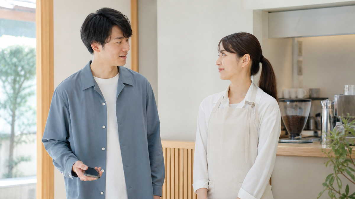 カフェ店内でスマホ撮影の許可をスタッフへ確認する男性