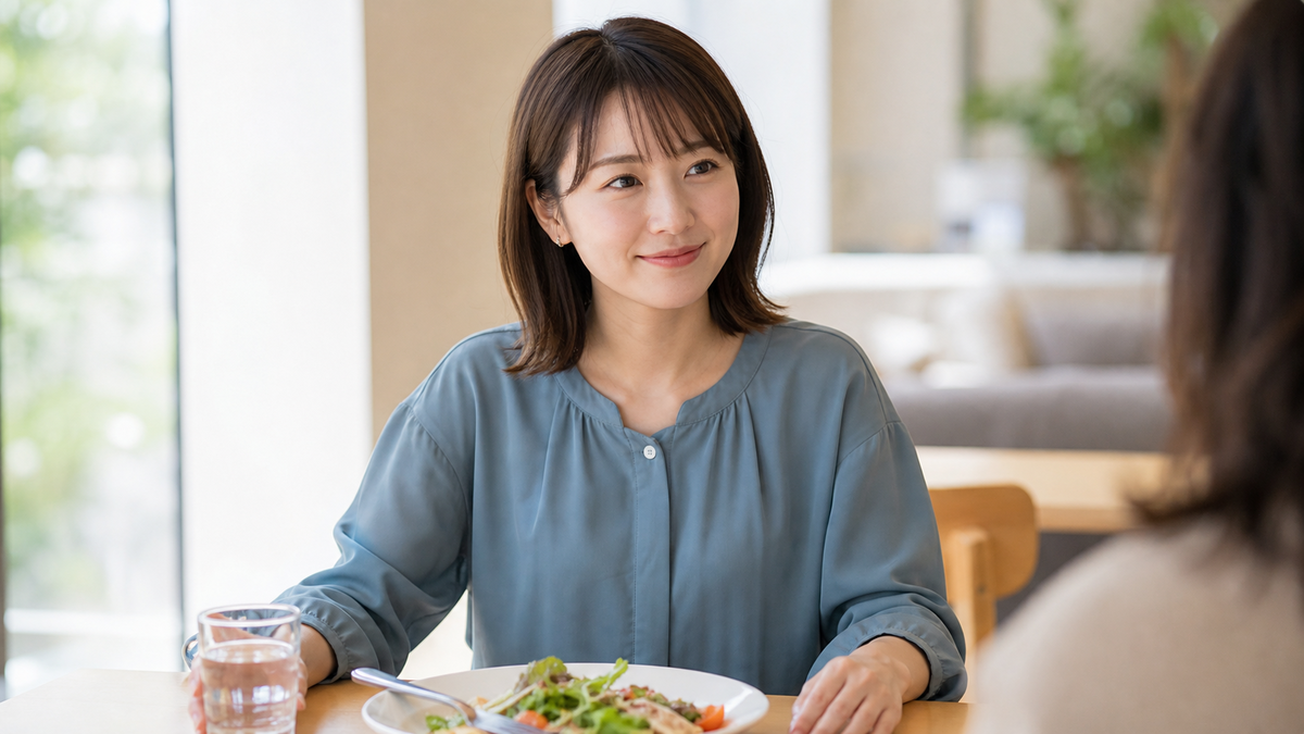 食事の合間に口元と手元を整えて自然に微笑む女性