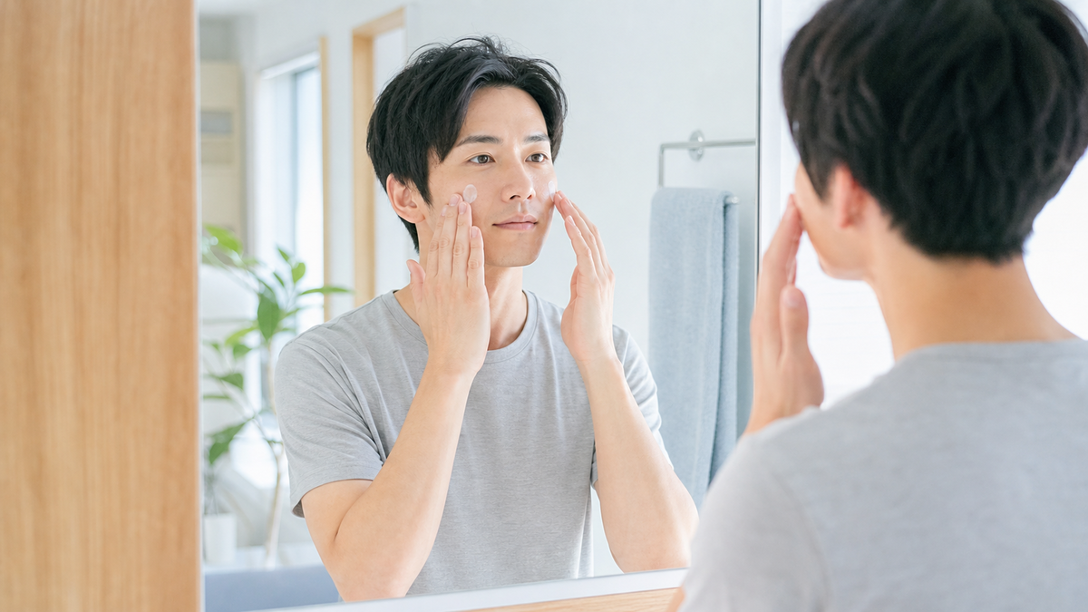 婚活写真の撮影当日の朝に洗顔後の保湿をなじませる成人男性
